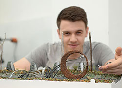 Cameron Lings with a model of his sculpture design 