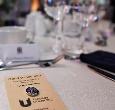 A pin celebrating the event is laid on a dinner table