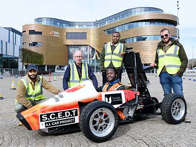 Pictured in the car is student Oluwafemi Akhigbe, with (left to right) student Kenny Omoworare, and academics from the School of Computing, Engineering and Digital Technologies, Alex Ellin, Chris Ogwumike and Hayder Hammood.. Link to Teesside University students creating AI controlled self-driving car.