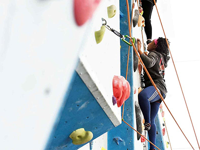 Female student, climbing on our climbing wall.. Female student, climbing on our climbing wall.. Link to Climbing for wellbeing.
