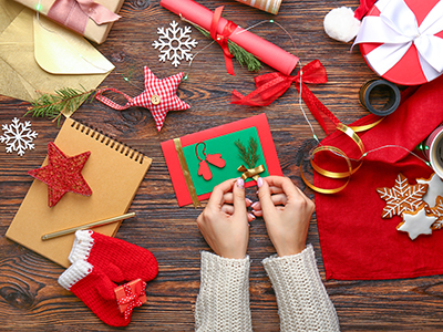 Woman with envelope and handmade Christmas card at wooden table. Link to Do Good, Feel Good – Christmas workshops 2025.