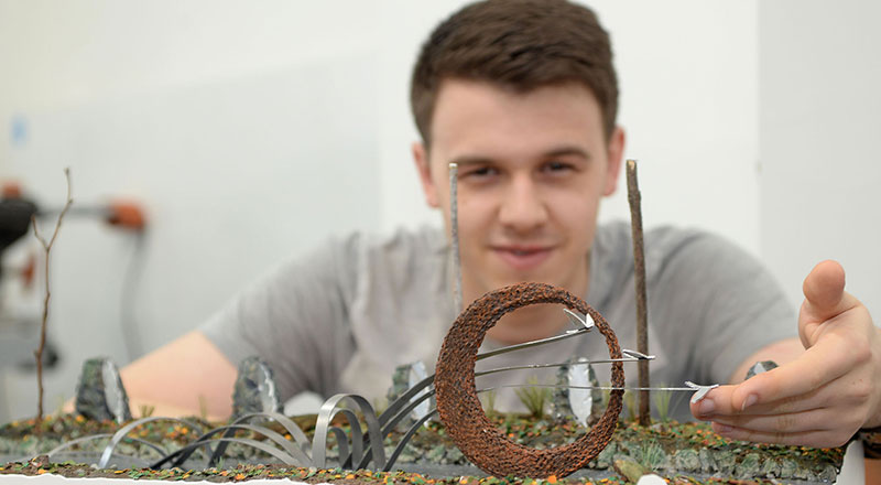 Cameron Lings with a model of his sculpture design 