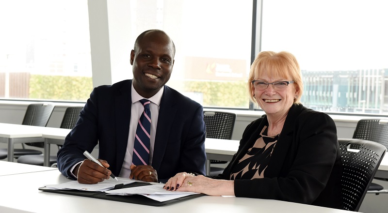 Edward Kunonga signing the memorandum of understanding with Marion Grieves.