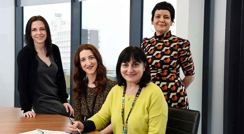 Signing the Memorandum of Understanding between Teesside University and Streetwise Opera. From left - Sarah O'Brien (Programme Leader in School of Computing, Engineering and Digital Technologies),  Ree Collins (Regional Programme Producer, Streetwise Opera), Professor Chrisina Jayne (Dean of the School of Computing, Engineering & Digital Technologies) and Siobhan Fenton (Associate Dean of the School of Computing, Engineering & Digital Technologies).