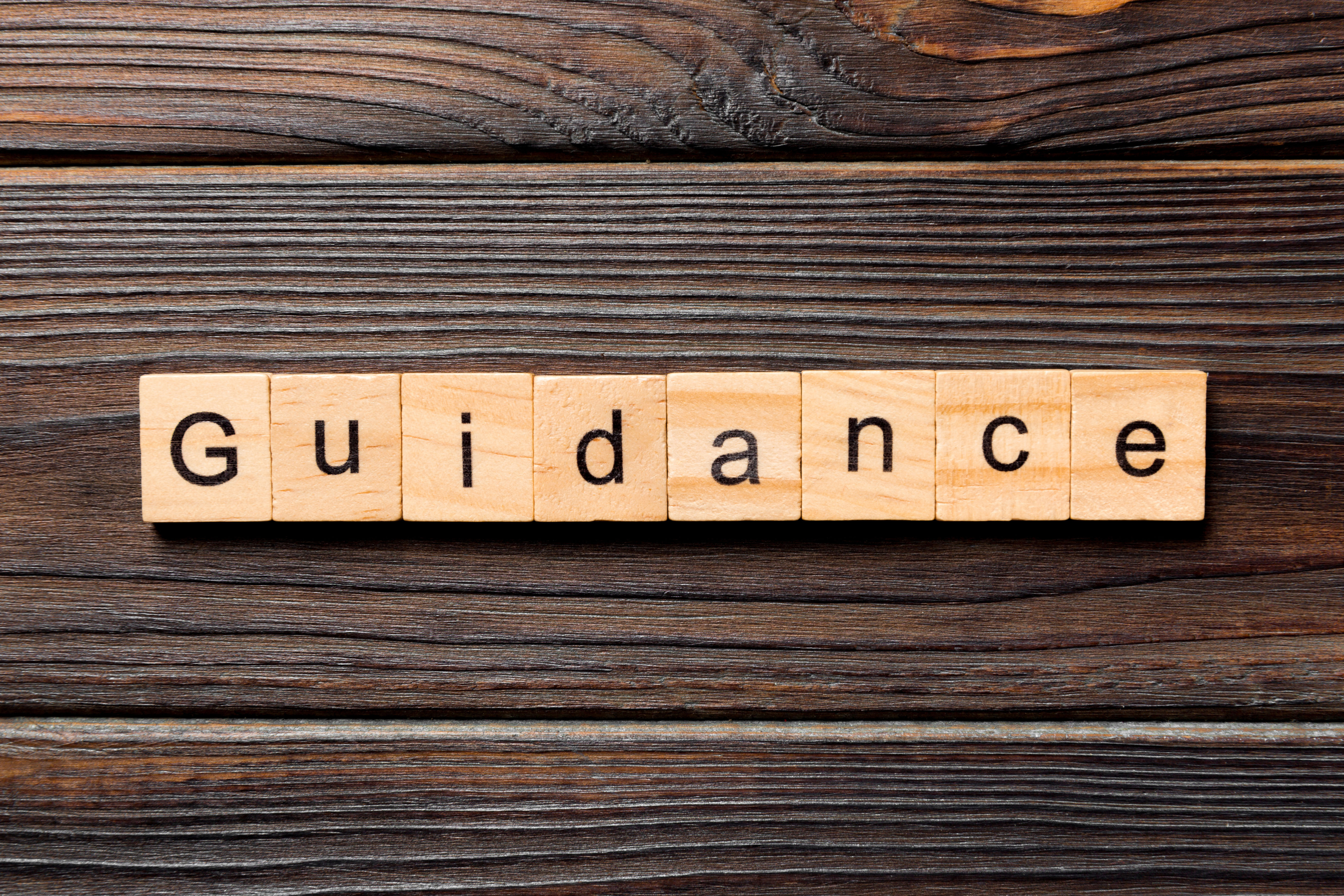 Square wooden blocks spelling the word 'guidance'