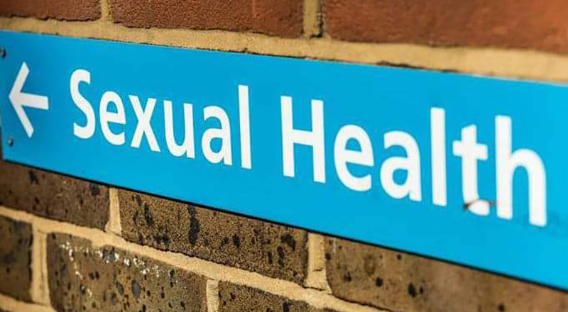 Sign (white text on blue background), on a wall, with the words 'Sexual Health'