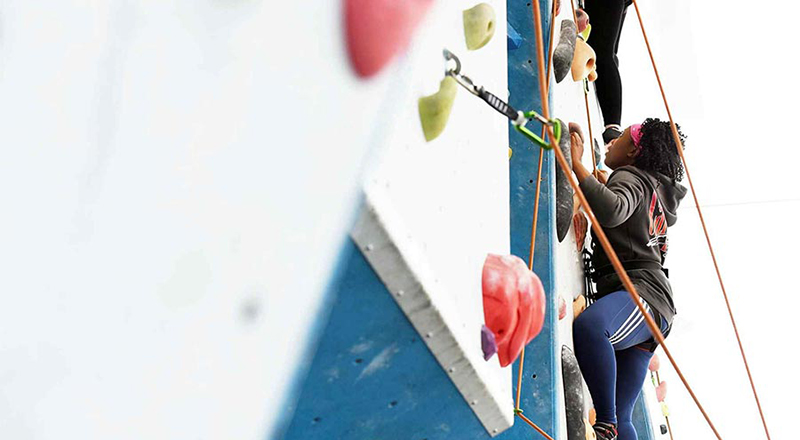 Female student, climbing on our climbing wall.