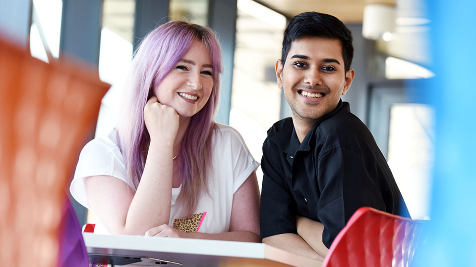Two students promoting diversity and Teesside University Proud