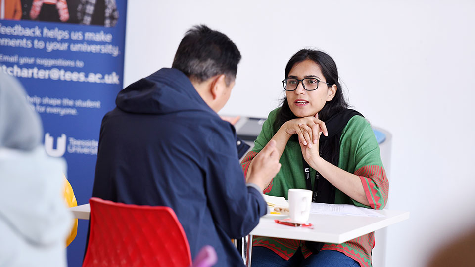 A supervisor and student discussing work together in an academic setting.