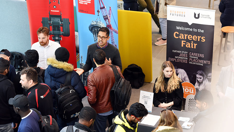 Students and employer representatives at a Teesside University careers fair exhibition stand