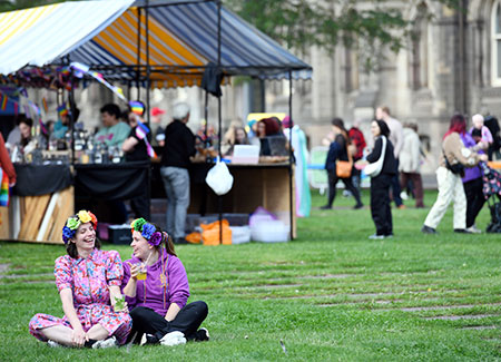 Orange Pip Market festival attenders walking through the festival stands, eating and dancing