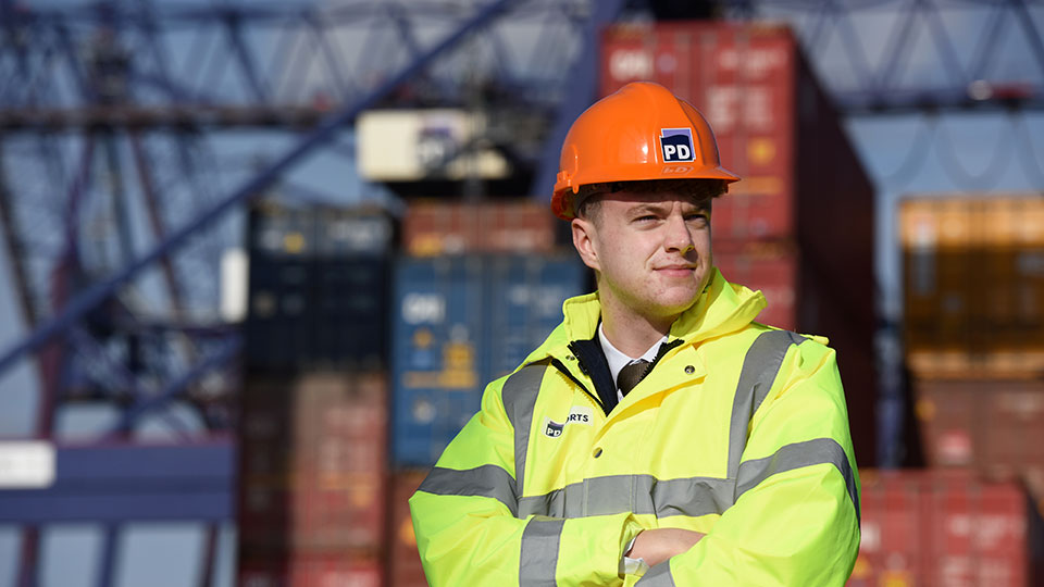 Teesside University student on an engineering placement wearing safety helmet at work site