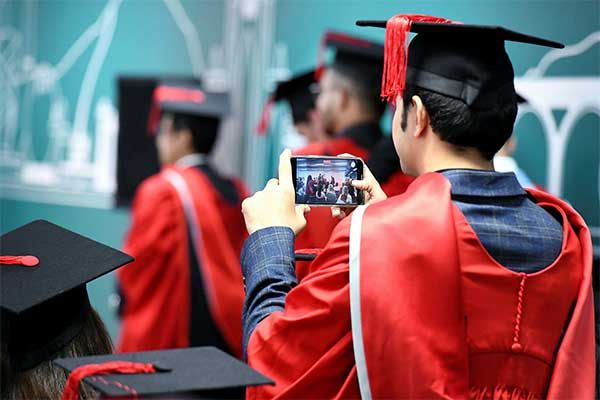 Graduating students celebrating in caps and gowns at Teesside University London