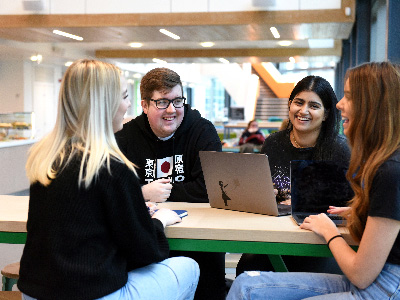 Staff sit in a table with computers in Student life building