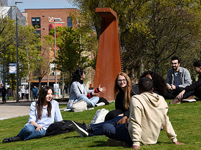 Students sitting on the grass in Campus Heart at Teesside University