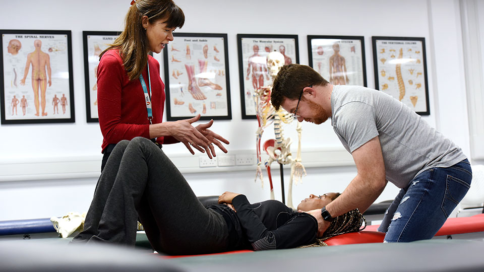 Student practicing chiropractic with a patient in the chiropractic clinic