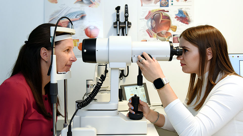 Optometry student performing an eye test to a patient