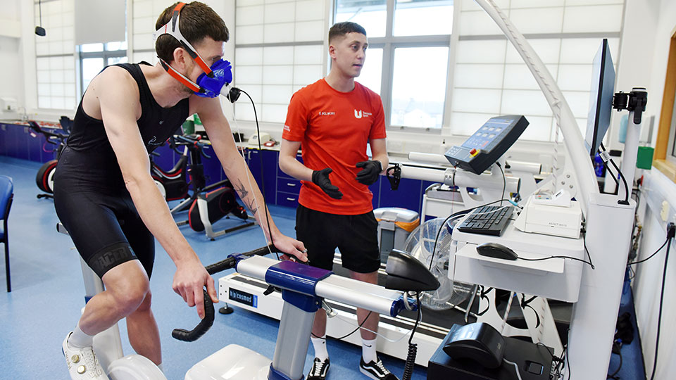 Performance scholar doing a physical performance test on a bike in the physiology labs