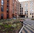 A small group of students walking outside the entrance of the Cornell Quarter student accommodation building at Teesside University