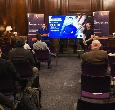 A lecture theatre with attendees watching George Clark answering questions