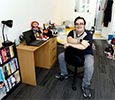Student sat in a room King Edwards Square Teesside University with Laptop, desk and bookshelf visible