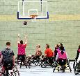 Students playing wheelchair basketball in the sports hall at Teesside University