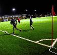 Students playing football on a floodlit 3G pitch at night at Teesside University