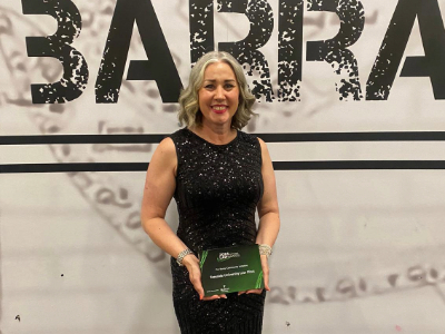 Emma Harbron smiling and holding an award