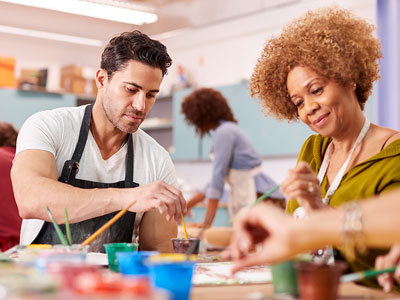 Two people painting at a table . Link to Two people painting at a table .