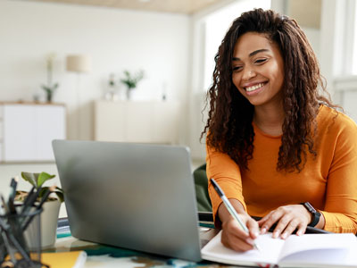 An image of a student writing in a notebook and working on a laptop.. Link to Moving from RefWorks -  Before 30 September 2026.