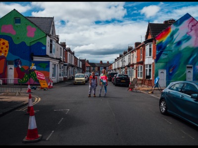 Artists Nocciola the Drawer (Hazel Oakes) and Hannah Campion with the murals. Link to Community-led murals celebrate stories of home in Middlesbrough.