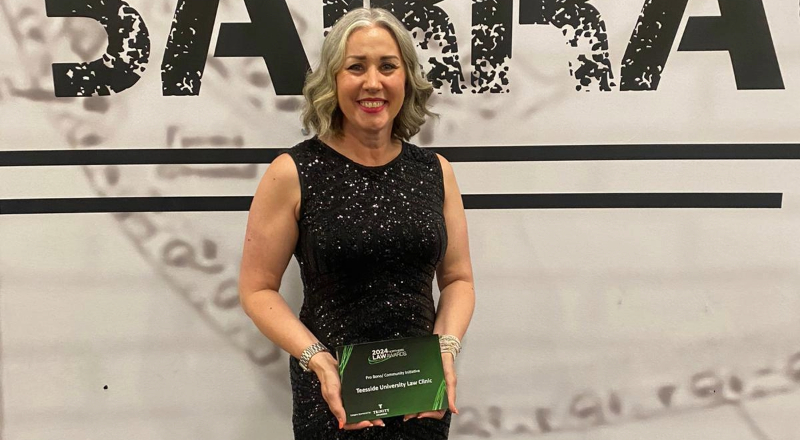 Emma Harbron smiling and holding an award