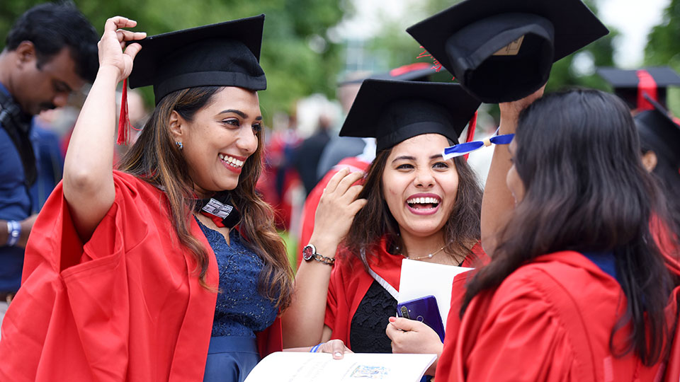 Graduated students in academic gowns celebrating their achievement at Teesside University