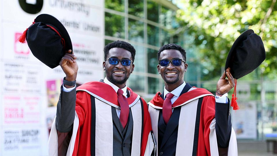 Graduates smiling wearing sunglasses