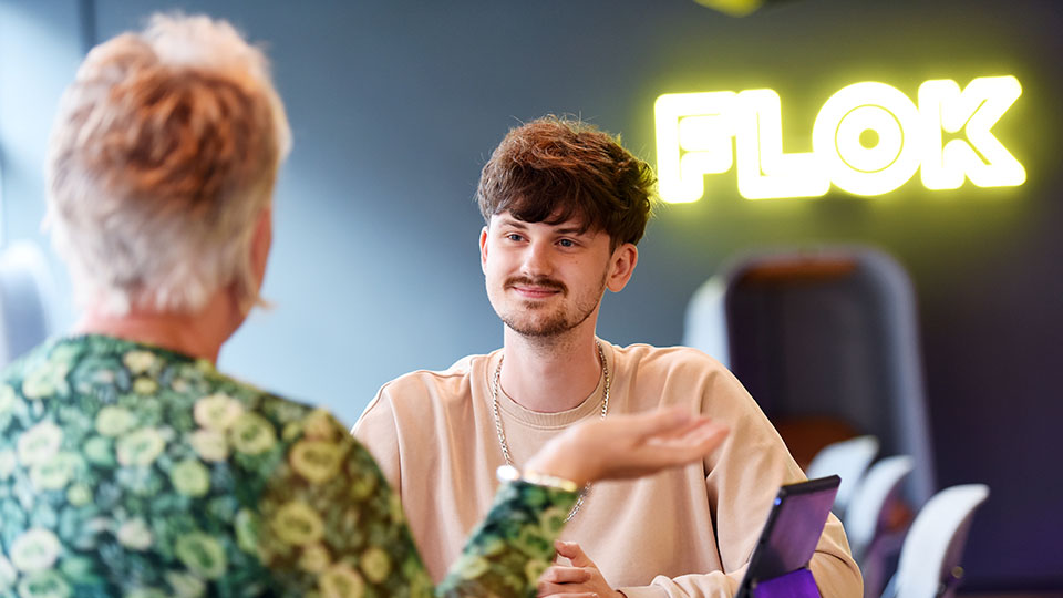 Students and staff collaborating with digital devices at Flok, Teesside University
