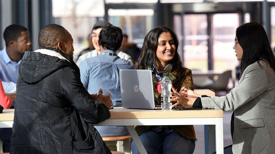 Teesside University students sitting and talking in the Student Life Building