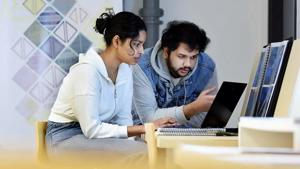 Two students using a laptop
