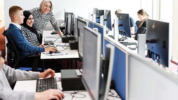 Students and staff in a University lab pointing at the compuer screen