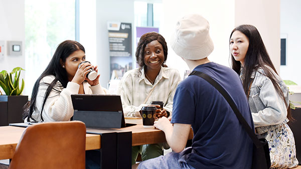 Group of students seated around a table working with a computer at Teesside University