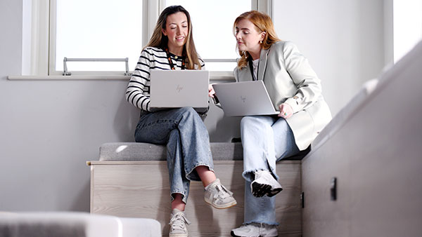 Students sitting around a table using a laptop while applying for postgraduate study