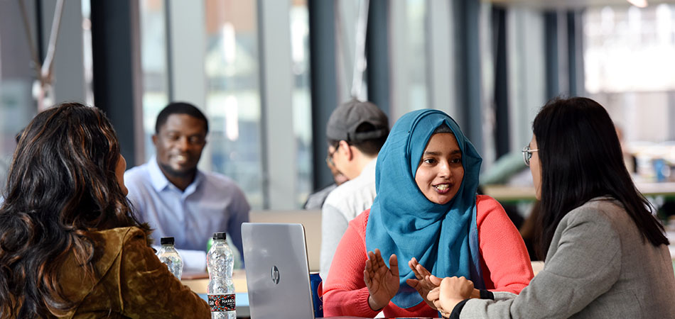 Students sit in table in a Teesside University building