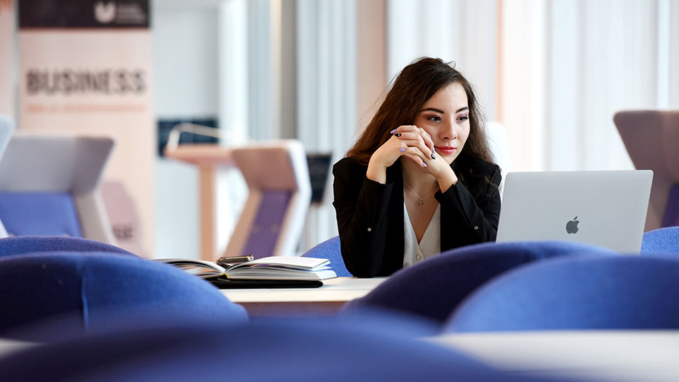 Supervisor and researcher sitting at a table with a laptop, discussing work