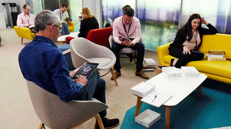 Staff members sitting in a relaxed sofa and armchair area at Teesside University