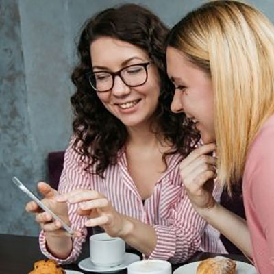 Teesside University staff members talking and looking at a phone on campus