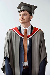 A grey gown, with Teesside University hood and grey mortar board with grey tassel