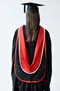 A black gown, with Teesside University hood, black mortar board with black tassel