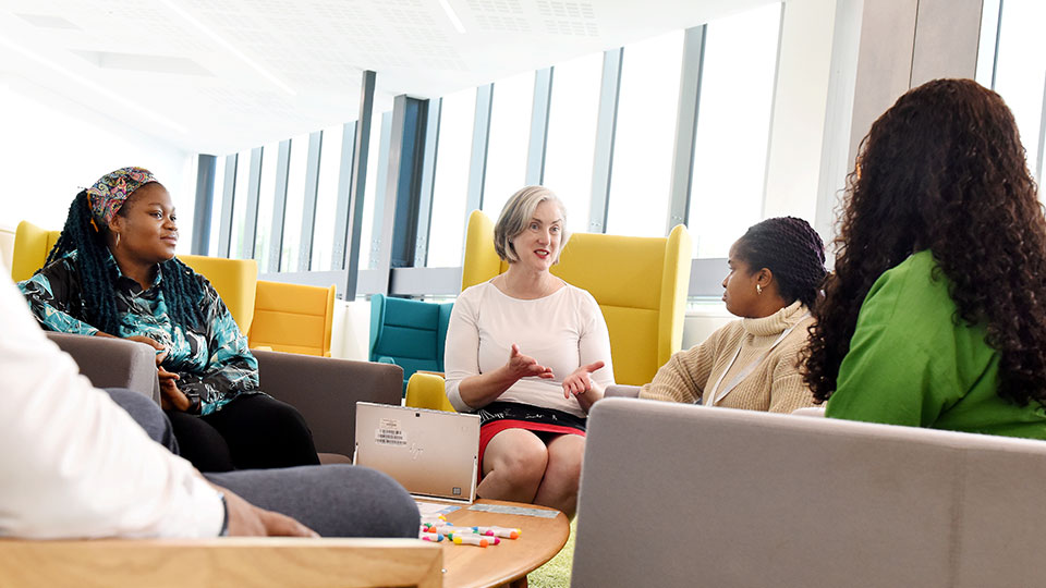 Student futures team sit in chair talking