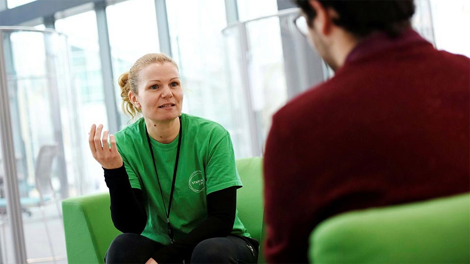 Student receiving support from staff in Student Life building