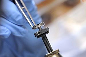 Research staff member using precision tools in a laboratory