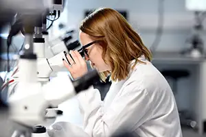 Research staff member using microscopy in a laboratory